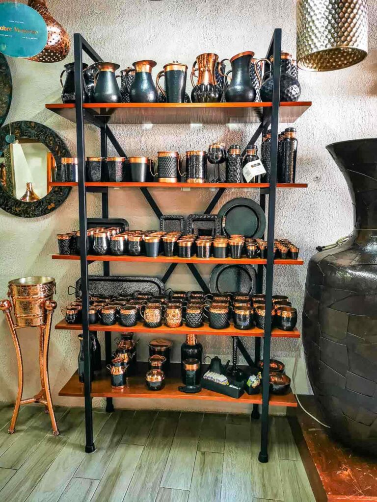 Different crockery painted black and with the top in copper on an open rack in Santa Clara, Mexico.