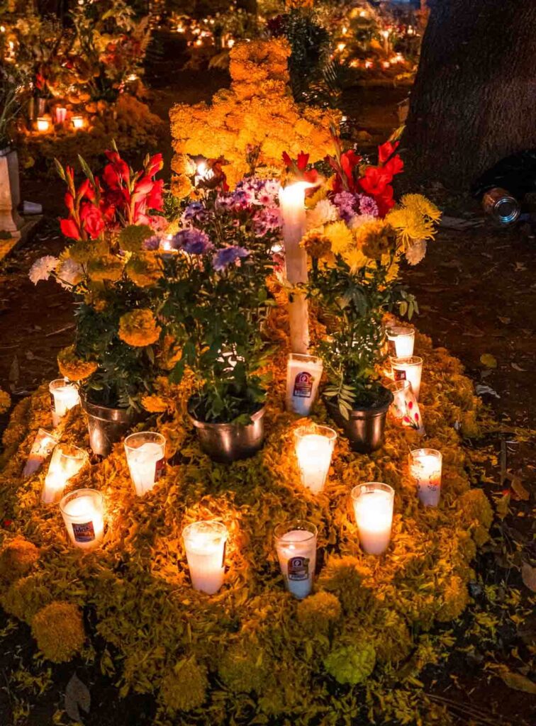 Candles lighted on a graveyard decorated with flowers on the Dia de Muertos in Patzcuaro.