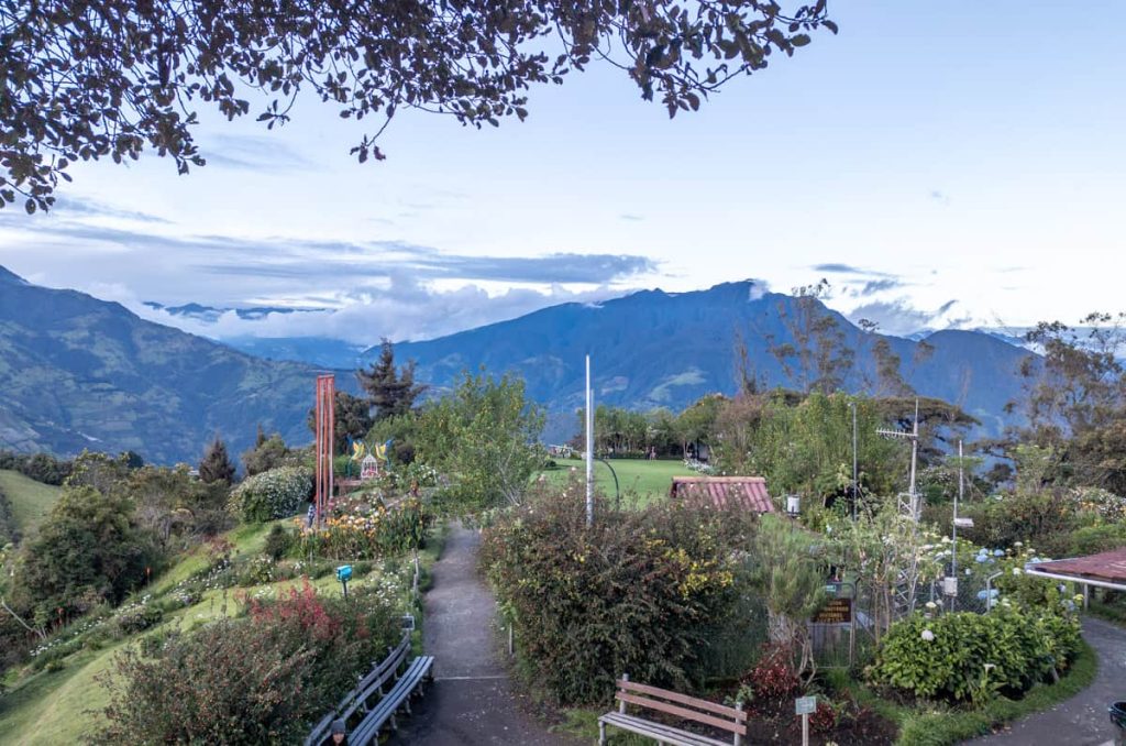 Gardens and a winding path leading toward the mountains at the famous swing at the end of the world in Baños, Ecuador.