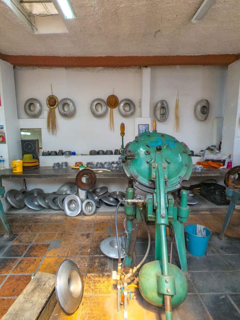At the Panama hat museum in Cuenca, metal hat forms and other equipment line the workshop.