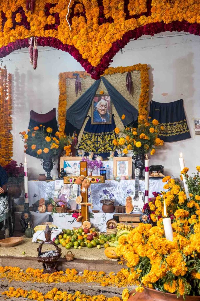 Flowers, candles and food being offered at the photo stand of Mama Coco on the Day of the Dead in Santa Fe Laguna.
