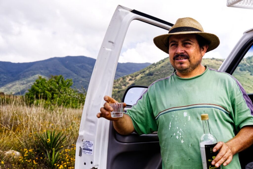 At the agave fields, Conejo pours tastings of mezcal to start the mezcal tour.