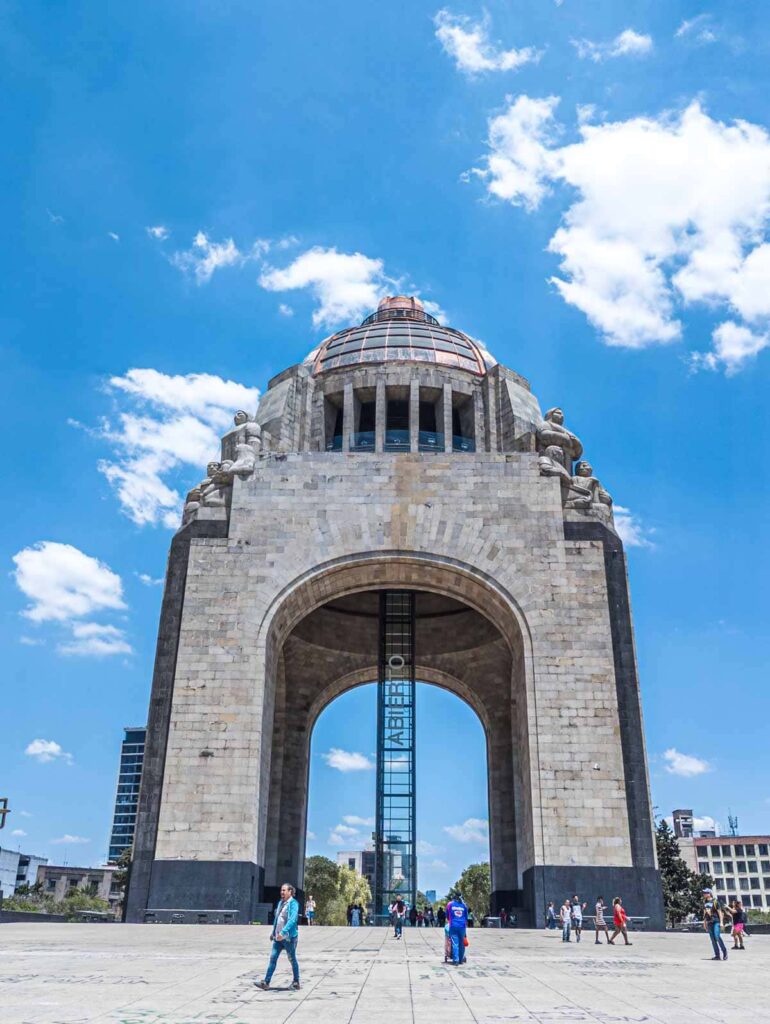 The exterior view of the Revolution Museum surrounded by people with a clear blue sky and white clouds.