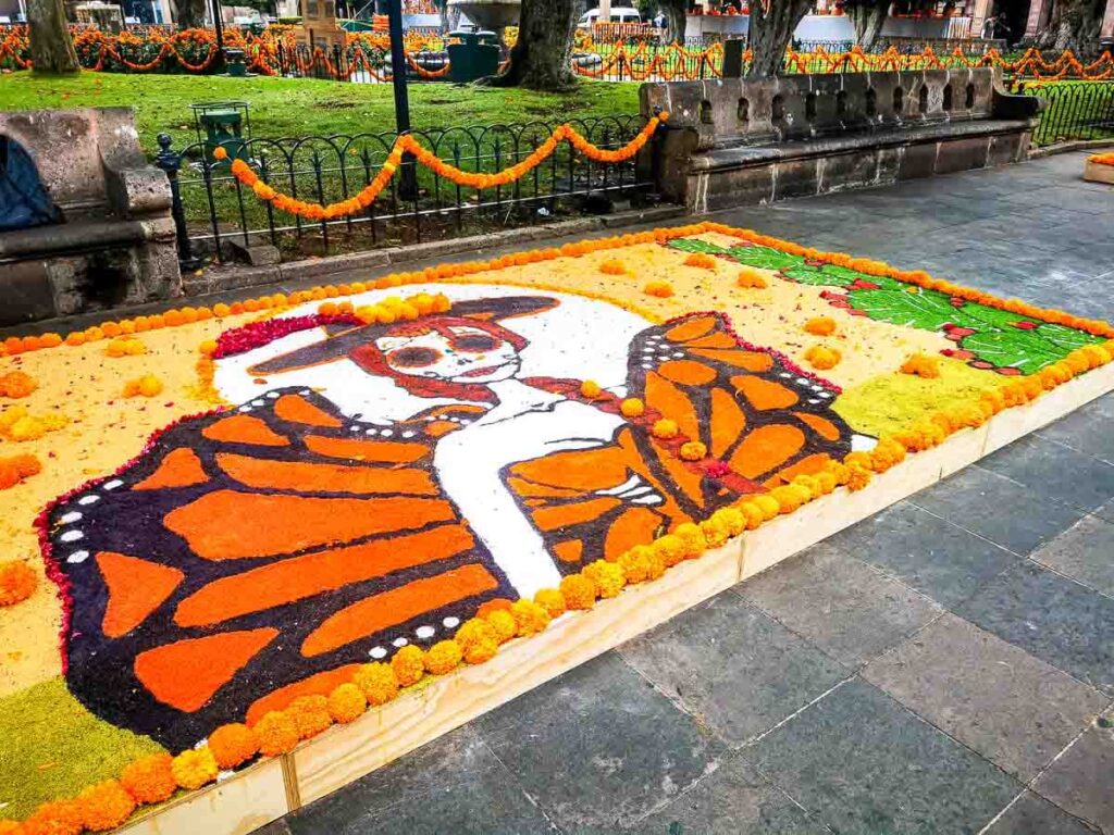 A sand paiting showing a girl in a Morelia butterfly dress with typical Dia de Muertos make-up in Michoacan.