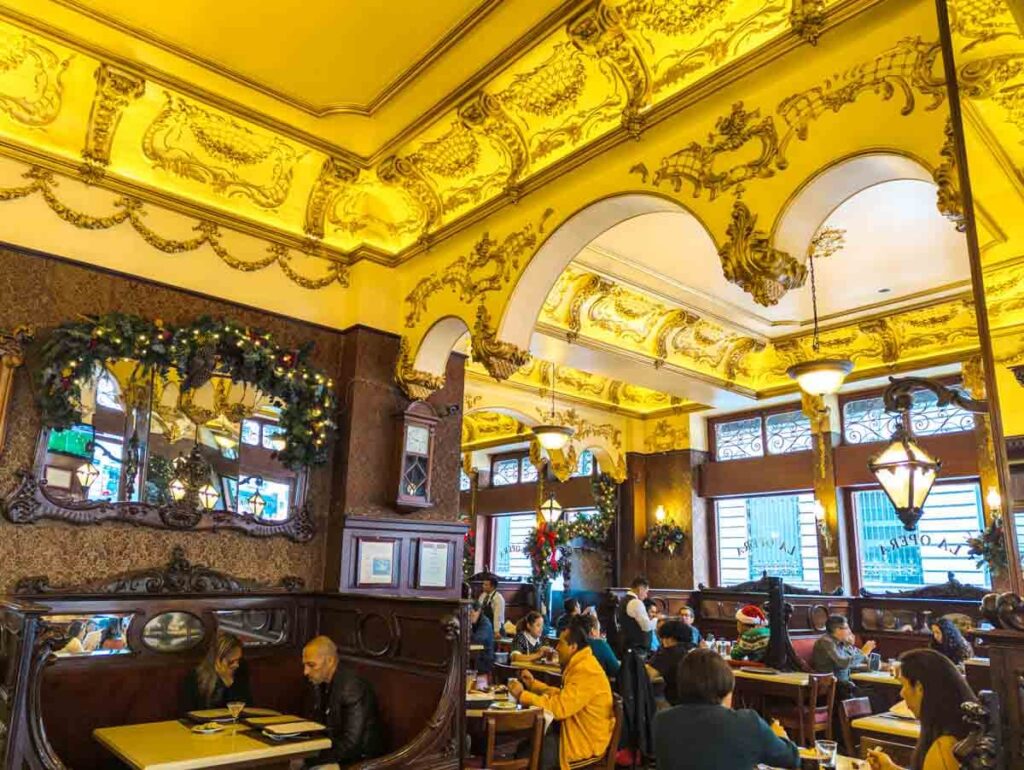 People drink and socialize at wooden booths inside Bar La Opera, one of the oldest cantinas in Mexico City.