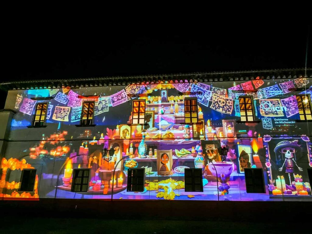 A colorful video is used for decorating a wall on the Day of the Dead in Patzcuaro showing candles, picture frames and more in a cartoonlike style.